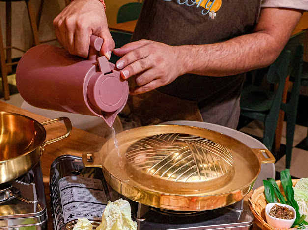 Preparing a traditional brass Mookrata grill
